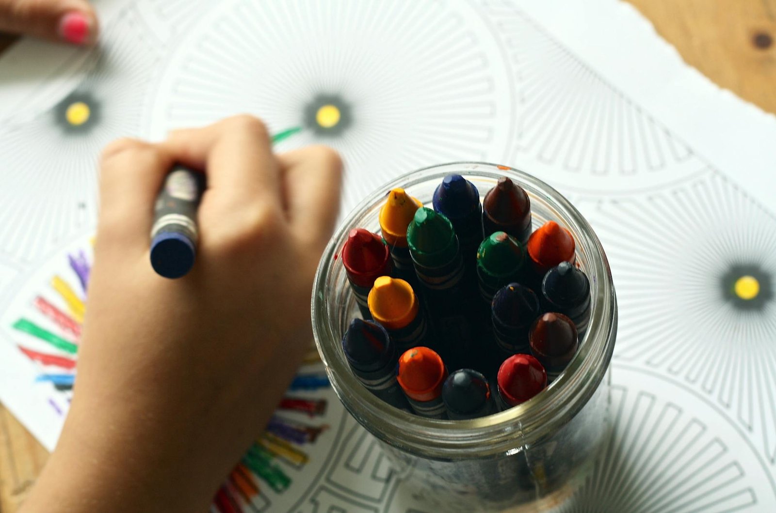 person coloring art with crayons